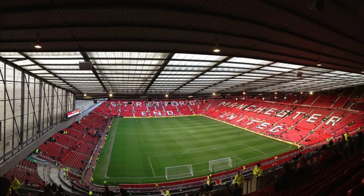 Interior view of Old Trafford with the pitch and stands visible.
